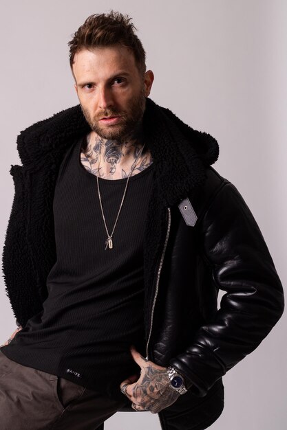 a man wearing a black leather jacket and a black jacket with a silver key on it.