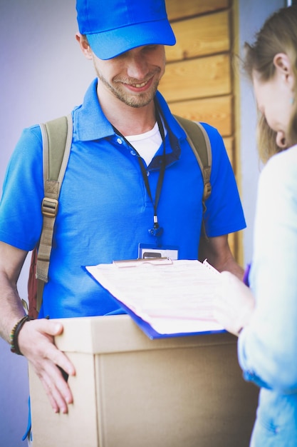 A man wearing a blue shirt is handing a box to a man.