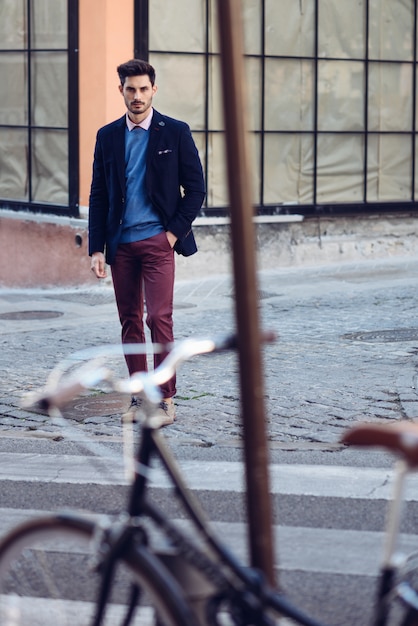 Man wearing british elegant suit in the street near an old bycicle