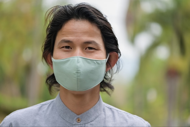 Man wearing a cloth mask in public area protect himself from risk of disease