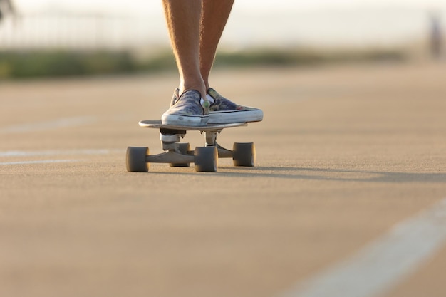 Man wearing colorful slipons skating on the street by the beach