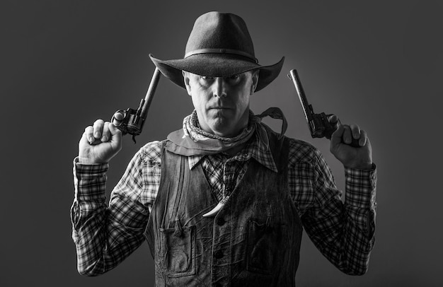 Photo man wearing cowboy hat, gun. portrait of a cowboy. west, guns. portrait of a cowboy. western man with hat. portrait of farmer or cowboy in hat