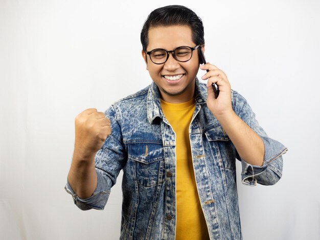 a man wearing a denim jacket talking on a cell phone.