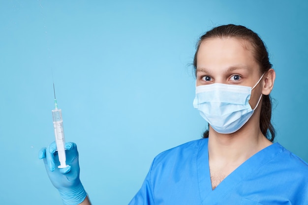 Man wearing doctor uniform holding syringe