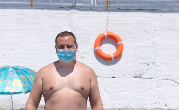 Uomo che indossa una maschera sulla spiaggia