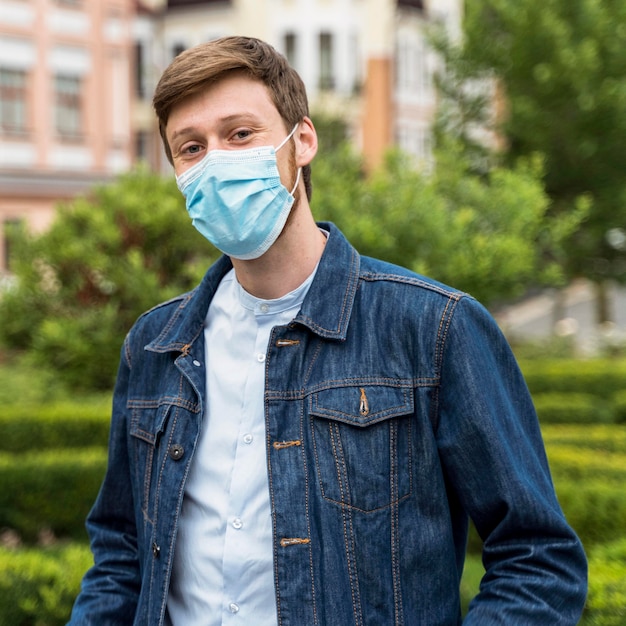 Foto uomo che indossa una maschera per il viso all'esterno