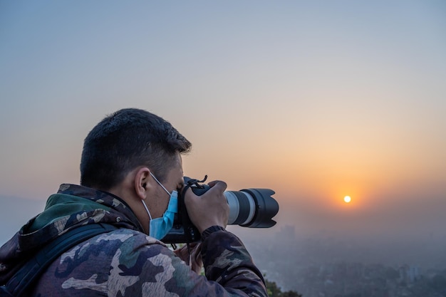 街中でマスクをした男性が太陽の写真を撮る。