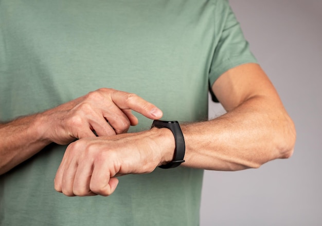 Uomo che indossa fitness tracker e controlla le metriche di salute dispositivo per il monitoraggio dell'attività fisica concetto di stile di vita sano