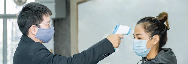 Photo man wearing flu mask checking temperature of woman