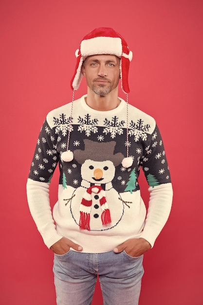 Foto uomo che indossa un divertente maglione lavorato a maglia e cappello per celebrare la festa di natale buon natale