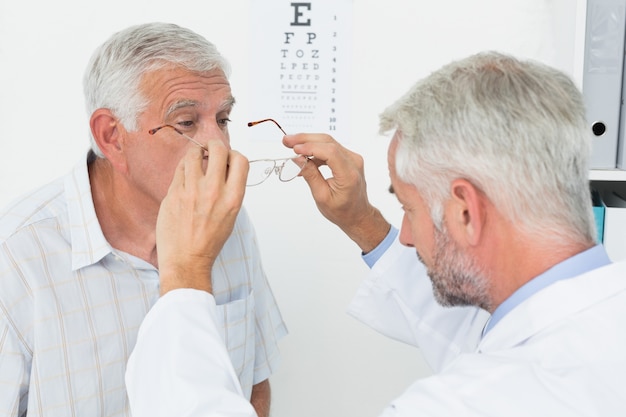 Equipaggi gli occhiali d'uso dopo la presa della prova della visione a medico