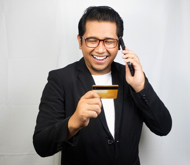 a man wearing glasses and a black jacket with a credit card in his hand.