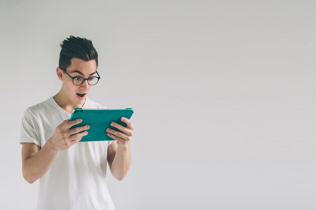 Man wearing glasses holds a tablet