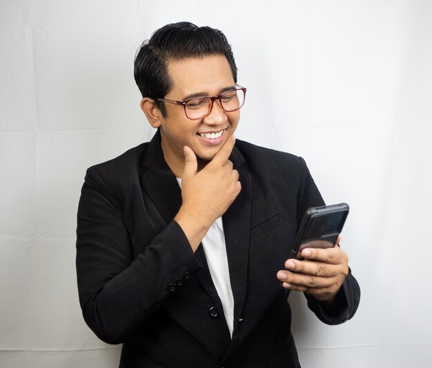 a man wearing glasses is looking at a phone.