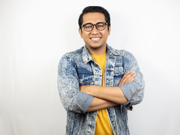 a man wearing glasses and a yellow shirt with his arms crossed.