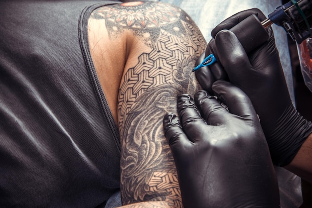 Man wearing gloves posing in tattoo studioProfessional tattooer at work in tattoo studio