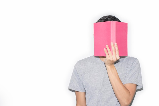 Man wearing a gray Tshirt holds his book off his face On a white background Copyspace