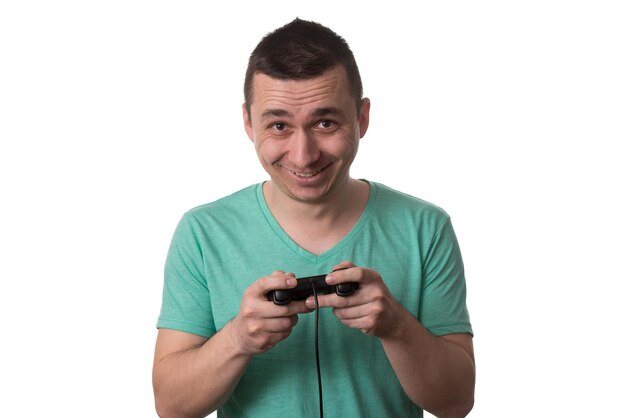 녹색 티셔츠를 입고 남자와 그는 절연 흰색 배경 위에 비디오 게임을 하고있다
