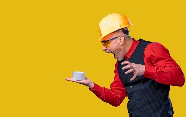 A man wearing a hard hat and holding a cup