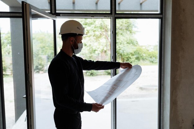 a man wearing a hard hat is holding a piece of paper