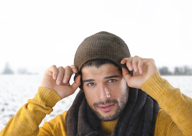 雪の風景の中で帽子とスカーフを身に着けている男