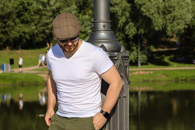 Photo man wearing hat standing by lake