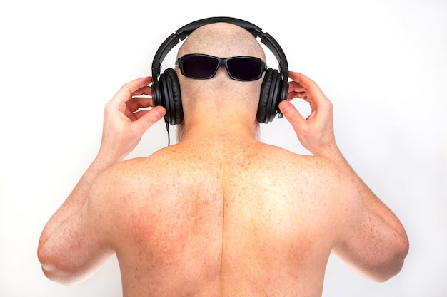 man wearing headphones listens to music view from the back audio sound style and technology