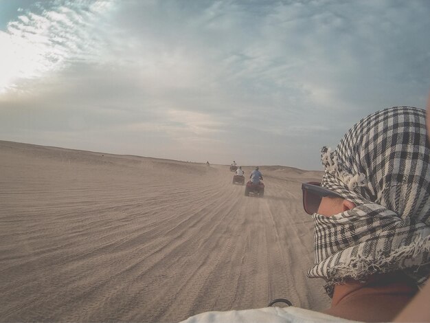 Foto uomo che indossa un velo nel deserto contro il cielo.