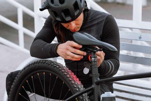 Man wearing a helmet adjusting bicycle lights