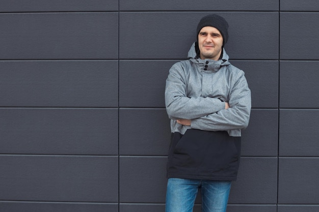 Foto uomo con cappuccio in piedi contro il muro