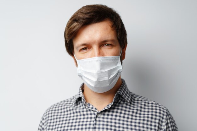 Man wearing hygienic mask against grey surface