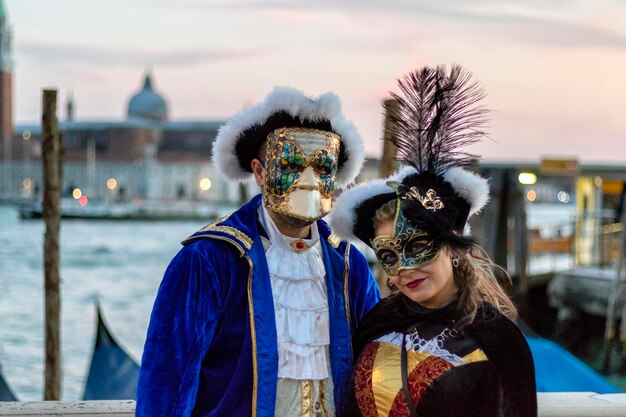 Foto uomo che indossa una maschera contro il cielo in città