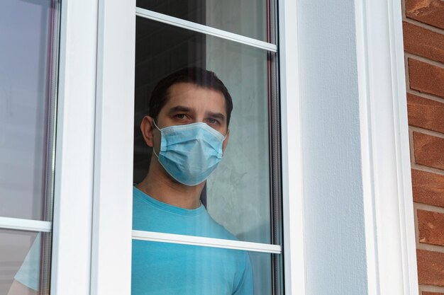 Man wearing mask seen through window