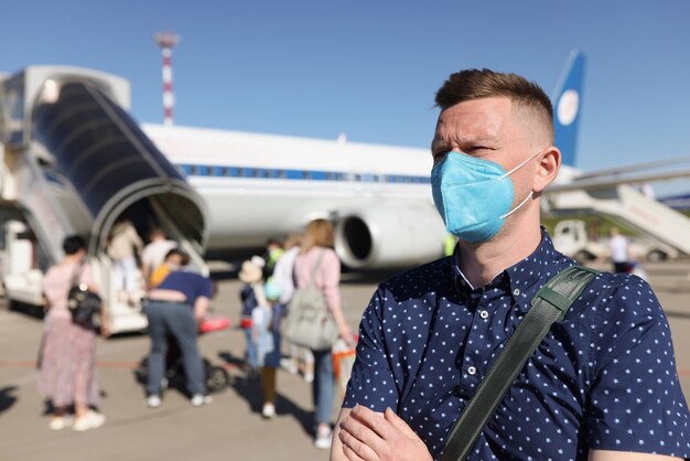 Uomo che indossa una maschera e in piedi vicino all'aereo