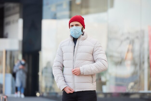 コロナウイルス（COVID-19）の蔓延を防ぐために医療用フェイスマスクをつけている男性。
