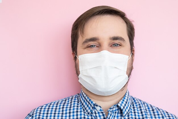 Man wearing medical mask on pink