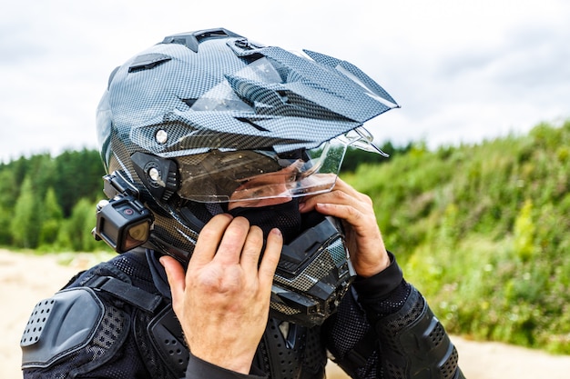 Man wearing motorcycle helmet on landscape