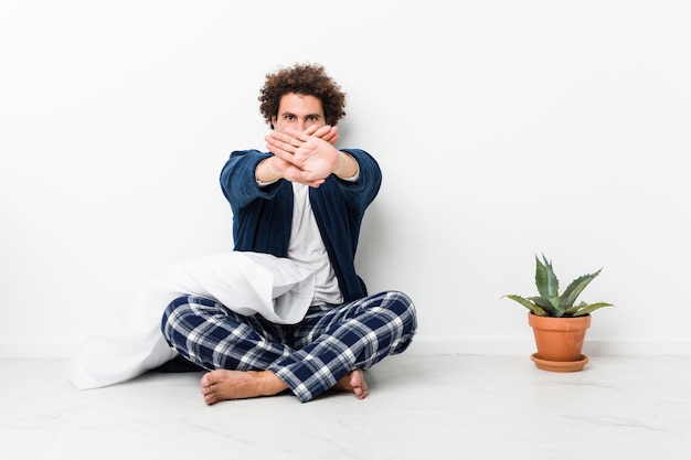 Photo man wearing pajamas doing a denial gesture