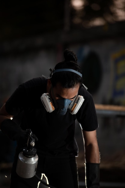 Photo man wearing protective mask holding equipment at workshop