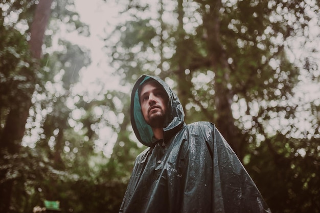 Man wearing a raincoat in a rainforest