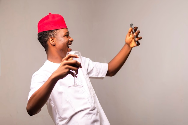 A man wearing a red hat and holding a cell phone