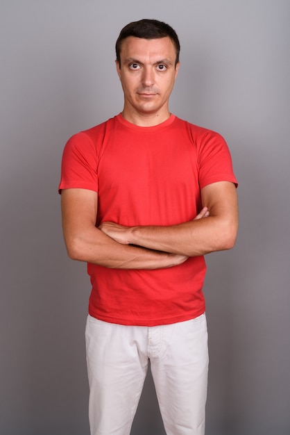 Man wearing red shirt against gray wall