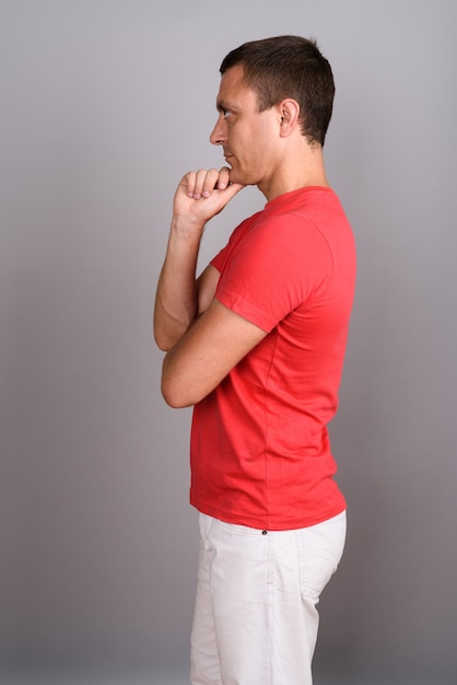 Man wearing red shirt against gray wall