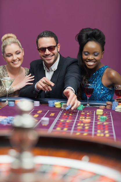 Photo man wearing sun glasses with women at roulette