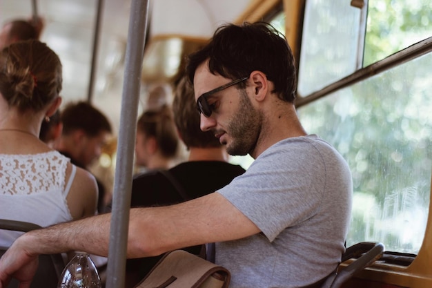 man wearing sunglasses while sitting in bus