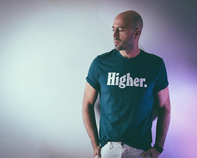 Photo man wearing t-shirt with text while standing against wall