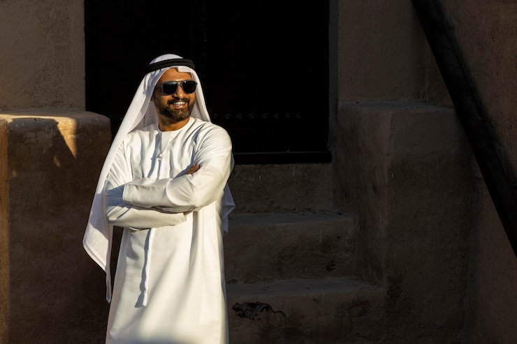 Photo man wearing traditional clothing standing against old built structure