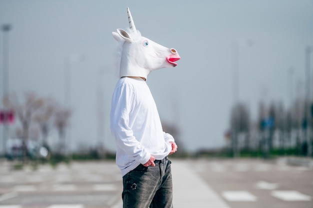 Foto uomo che indossa la maschera di unicorno in posa