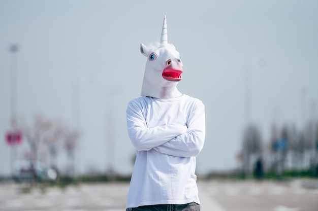 Foto uomo che indossa la maschera di unicorno in posa
