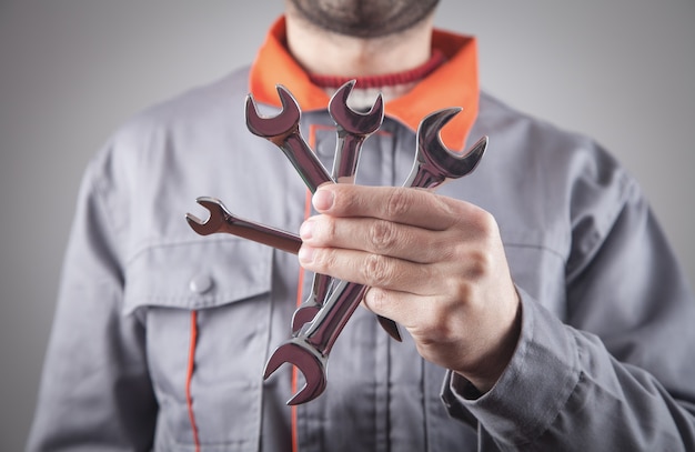 Man wearing a uniform holding a wrench